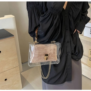 Detail of transparent PVC handbag featuring bamboo handle and woven interior pouch