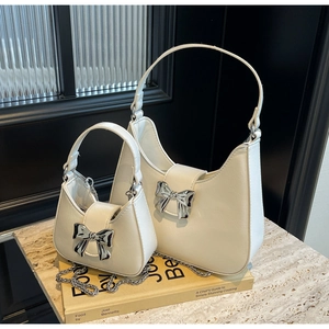 Detailed comparison of large and small white bow-accented handbags with silver chains