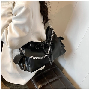 Detail einer großen schwarzen PU-Ledertasche mit Silberkette und Schleifendetail