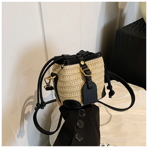 Mini straw bucket bag with black leather trim and gold metal clasp in crossbody style