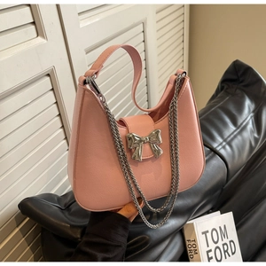 Close-up of pink crescent handbag with silver bow buckle and elegant metal chain details