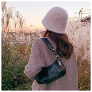 Chic black patent leather shoulder bag with silver studs worn with oatmeal blazer and hat