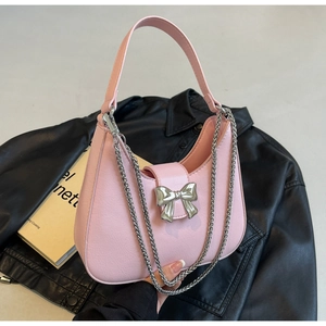 Detailed macro view of pink half-moon bag with silver bow accent and lychee grain texture