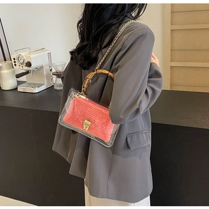 Detail of transparent PVC crossbody bag with pink woven inner and bamboo handle