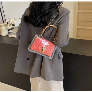 Detail showing transparent PVC tote with red woven pouch and bamboo handles