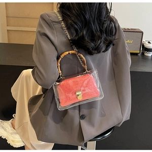 Detail of transparent PVC crossbody bag with bamboo handle and pink woven inner pouch