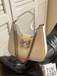 White crescent moon shoulder bag with silver bow accent and delicate chain strap detail
