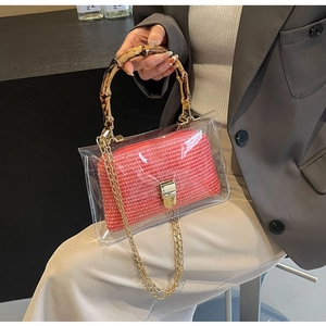 Detail of transparent PVC handbag with bamboo handle and pink woven inner pouch