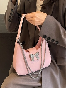 Chic pink saddle shoulder bag with silver bow decoration and dual metal chains