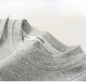 Dettaglio di una t-shirt grigia in maglia a girocollo con cuciture doppie resistenti