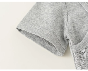 Dettaglio manica t-shirt grigia con inserto in pizzo floreale bianco e cuciture piatte
