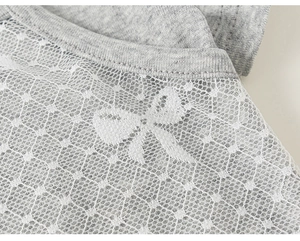 Dettaglio di tessuto a maglia grigio con pizzo bianco e motivo a farfalla fine
