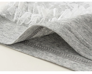 Dettaglio in primo piano del tessuto a maglia grigio con pizzo floreale bianco