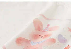 Detail of breathable eyelet fabric with a pink cartoon rabbit print for kids clothing