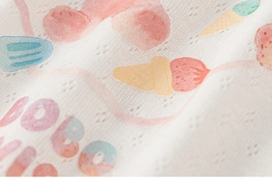 Close-up of soft pointelle knit fabric with ice cream patterns and BOBO lettering