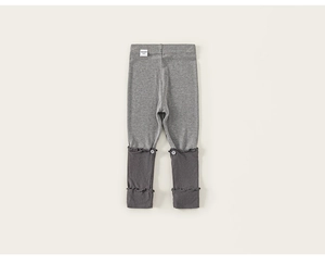 Gedetailleerd overzicht van de grijze patchwork legging voor kinderen met ruches en knopen
