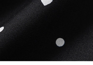 Macro shot of black fabric with white polka dots showing soft texture and fine weave