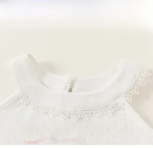 Detail of girls white knit top featuring lace collar and delicate hollow diamond pattern