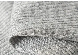 Detail shot of light grey ribbed knit fabric showing the soft fiber texture and elasticity
