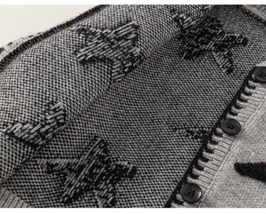 Detailweergave van de jacquardgebreide sterpatroon en knoopsluiting op het kindervest