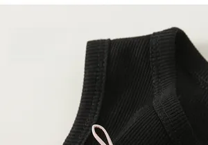 Detail of soft ribbed knit fabric with a sweet pink bow on a sleeveless girl dress