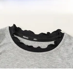Detail of grey ribbed girls top featuring black lace trim collar and soft texture