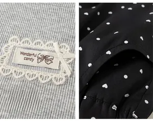Detail of girls sleeveless top with lace heart patch and polka dot pocket shorts