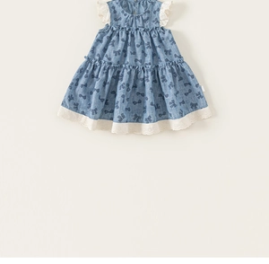 Detailed close-up of blue bow print fabric with white lace trim on the girl's dress