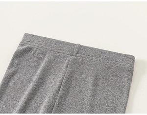 Detail van grijze gebreide katoenen broek met elastische tailleband en platte naden