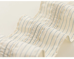 Detail of soft striped cotton fabric with textured pleats and fine sewing craftsmanship
