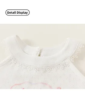 Detail of baby girl white cotton knit top with floral lace collar and pink print