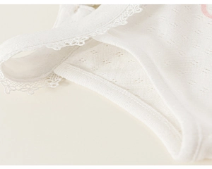 Close-up of white breathable mesh fabric with delicate lace embroidery and soft texture