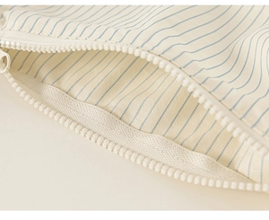 Close-up of durable white plastic zipper on striped fabric kids' two-piece outfit