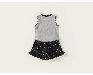 Close-up of girls' sleeveless knit top with ruffled polka dot shorts detailing