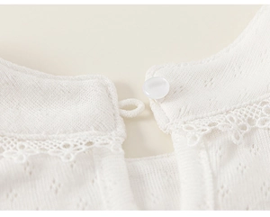 Macro view of white knitted fabric with breathable texture and delicate lace collar detail