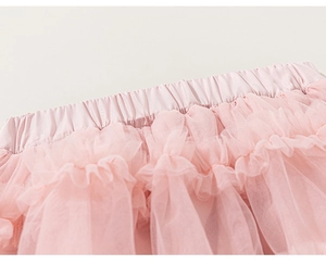 Detailed macro view of soft pink layered mesh tutu skirt with satin elastic waistband