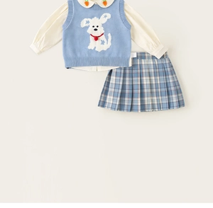 Detalle del chaleco de punto para niña con perro y camisa con bordado de zanahoria