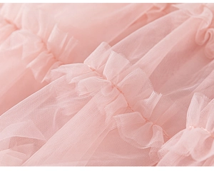 Detailed macro shot of pink multi-layered mesh fabric with delicate pleated ruffles