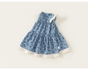 Close-up of baby girl blue dress showing lace trim edges and navy bow patterns