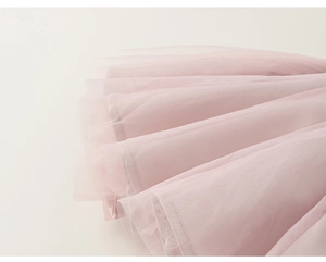 Close-up of soft pink layered tulle mesh fabric on sleeveless toddler dress