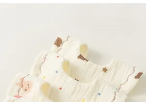 Close-up of baby cotton gauze bib featuring cute bear and rabbit cartoon patterns