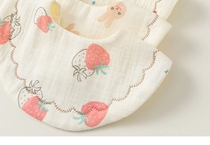 Detailed view of layered cotton gauze baby bibs featuring strawberry and rabbit patterns
