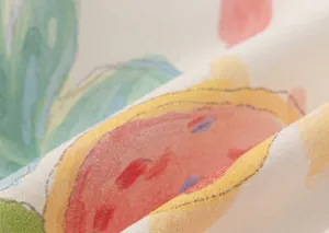 Nahaufnahme von Baumwollstoff mit farbenfrohen Wassermelonen- und Blattmustern