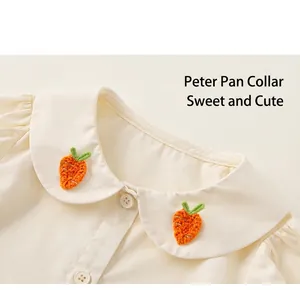 Detalle de camisa crema para niña con cuello Peter Pan y bordado de zanahoria suave
