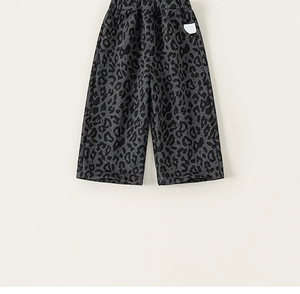 Detailed close-up of leopard print loose pants with elastic waist and white logo patch