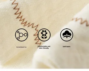Macro detail of beige baby bib fabric with brown zigzag stitching and soft texture