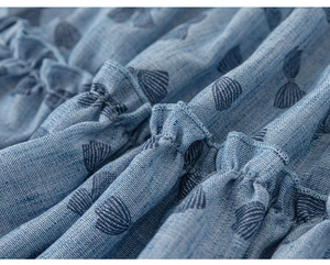 Detailed macro view of blue printed fabric with ruffles and cross-weave texture