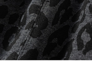Close-up of knit fabric with grey and black leopard pattern showing soft texture