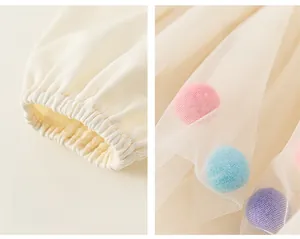 Détail des poignets élastiques et du tulle avec des pompons colorés doux sur la jupe