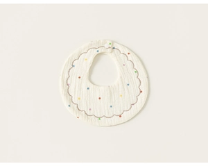 Close-up of soft cotton baby bib with colorful polka dots and wave stitching detail